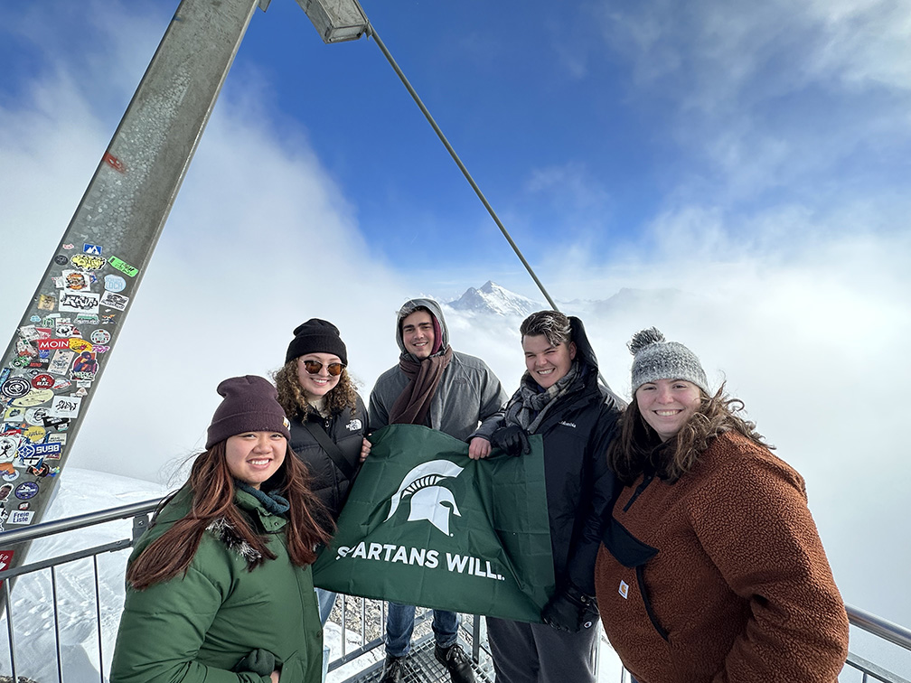 Group of students posing on a mountain top in switzerland