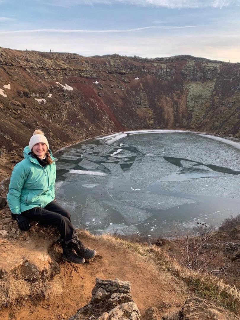 Student posing near a frozen body of water